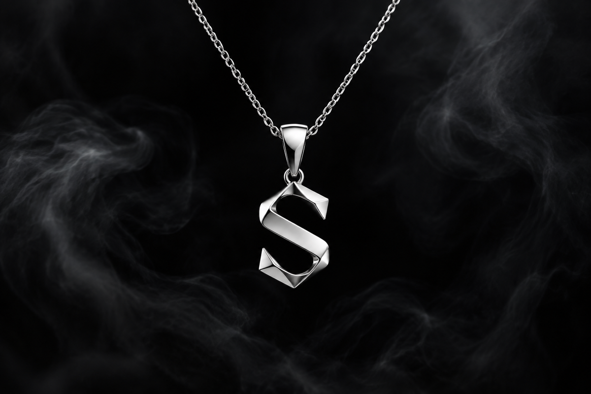 The Saintarini S Pendant in white gold — the house letterform on a dark backdrop (placeholder image, to be replaced with the production photograph)